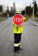 Masked flagger at work holding stop sign