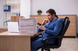 © Elnur - Young male employee unhappy with excessive work in the office
