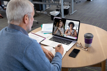 Sticker - Caucasian man in office having video call with colleagues displayed on laptop screen