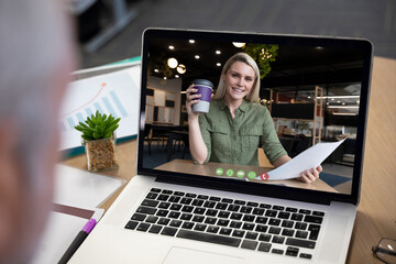 Sticker - Caucasian businesswoman having coffee holding documents displayed on laptop screen during video call