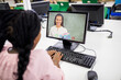 © vectorfusionart - Mixed race schoolgirl using computer on video call with female teacher
