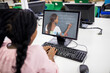 © vectorfusionart - Mixed race schoolgirl using computer on video call with female teacher