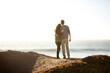 © Cavan Images - Rear view of couple embracing on shore against clear sky