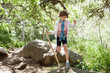 © Cavan Images - Girl holding stick while hiking in forest