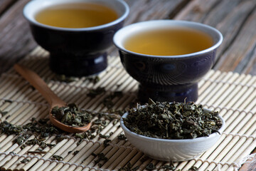 Leafy green tea next to two containers