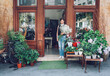 © Cavan Images - Female florist holding white flowers while standing entrance of shop
