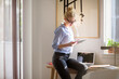 © Cavan Images - Woman using tablet computer while sitting on table at home