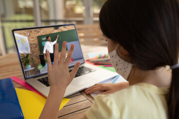 Poster - Female student wearing face mask having a videocall with male teacher on laptop at home