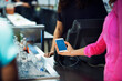 © Cavan Images - Cropped image of woman scanning smart phone while paying bill in restaurant