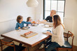 © Cavan Images - Family raising celebratory toast while sitting at dining table in home