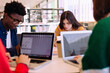© Cavan Images - Friends studying while sitting at table in library