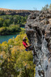 © Cavan Images - High angle view of man climbing on rock against clear sky