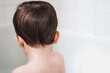 © Cavan Images - Rear view of shirtless boy in bathtub at home