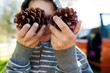 © Cavan Images - Boy in hooded shirt holding pine cones