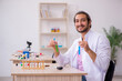 © Elnur - Young male chemist sitting at the desk in the classroom