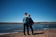 © Cavan Images - Couple standing at beach against clear blue sky during sunny day