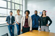 © Cavan Images - Portrait of confident business people standing by table in office