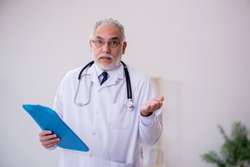 Old male doctor working in the clinic