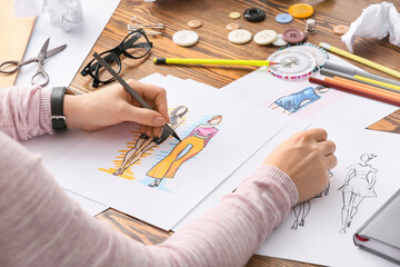 Poster - Female fashion designer working with sketches in studio, closeup