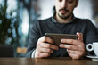© Cavan Images - Businessman using smart phone while sitting in cafe