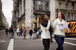 © Cavan Images - Happy female friends giving high five while walking on street