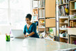 © Cavan Images - Confident businesswoman working on laptop computer at table in office