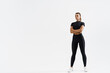 © Liubov Levytska - Determined sports woman in sport clothing standing on white background with crossed arms. Confident fitness female looking away, training and exercising concept