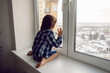 © saulich84 - child boy sits on a window sill in winter on a high floor