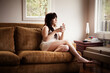 © Cavan Images - Woman with coffee cup relaxing on sofa