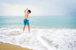 © Cavan Images - Young teen surfing on seashore in sunny day