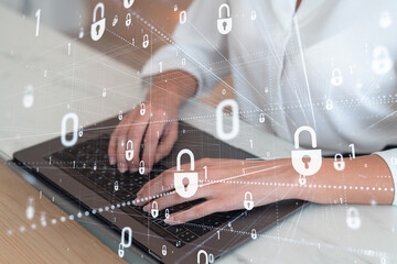 A woman programmer is typing a code on computer to protect a cyber security from hacker attacks and save clients confidential data. Padlock Hologram icons over the typing hands. Formal wear.