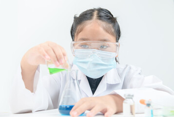 Wall Mural - a little scientist is pouring green liquid chemical in erlenmeyer flask isolated