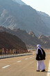 a Bedouin man stands on the road waiting for transport, Wady Megarah, Sinai, Egypt