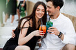 © taras.chaban - couple seating on the beach bar and drink cocktails. couple drink cocktails