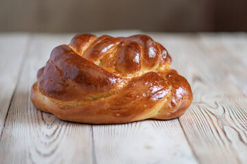 Loaf of homemade wicker white bread on a wooden background, close-up.