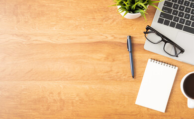 Wall Mural - flat lay of office desk with laptop, and blank notepad with a coffee cup on wood table, copy space, 