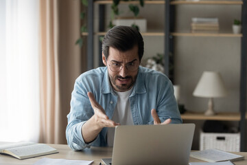 It makes no sense. Shocked young guy software developer look at laptop screen unable to find fix error in program code. Annoyed man enterpreneur get rejection of profitable offer from business partner