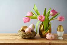 Easter Holiday Concept With Beautiful Tulip Flowers, Pink And Golden Eggs On Wooden Table