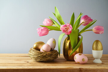 Wall Mural - Easter holiday concept with beautiful tulip flowers, pink and golden eggs on wooden table