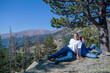 © Cavan Images - Children sitting together on a boulder looking camera