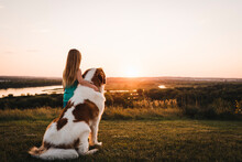 Little Girl Watches Sunset With Saint Bernard Dog Overlooking Missouri River In Bismarck North Dakota