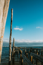 Vertical View Of Pier Remnants Against A Blue Sky