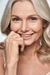 © insta_photos - Happy pretty 50s middle aged woman touching healthy soft face skin, smiling, looking at camera. Anti age healthy skincare treatment and cosmetic ads. Face close up view crop detail headshot portrait