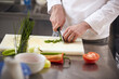 © Cavan Images - Close-up of chef chopping vegetables on cutting board at commercial kitchen
