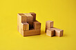 © Svetlana - Logical game wooden cube puzzle the last element lies next to the yellow background close up. Solving logical problems. High quality photo