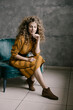 © Cavan Images - Young beautiful curly woman stands on the office in a retro dress