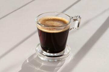 Black coffee in a glass cup and saucer 