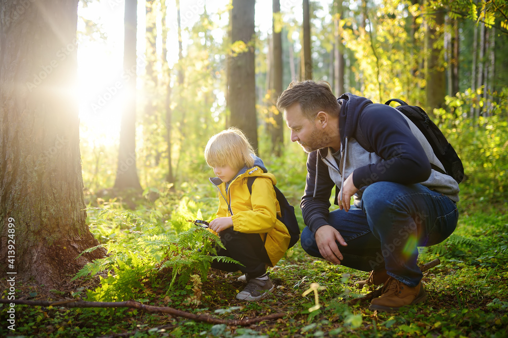 School boy and his father hiking together and exploring nature with ...