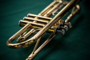 Close up macro still life of brass trumpet on green background