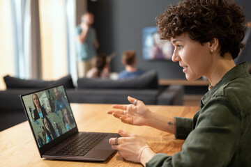 Sticker - Side view of contemporary businesswoman talking to colleagues in video chat